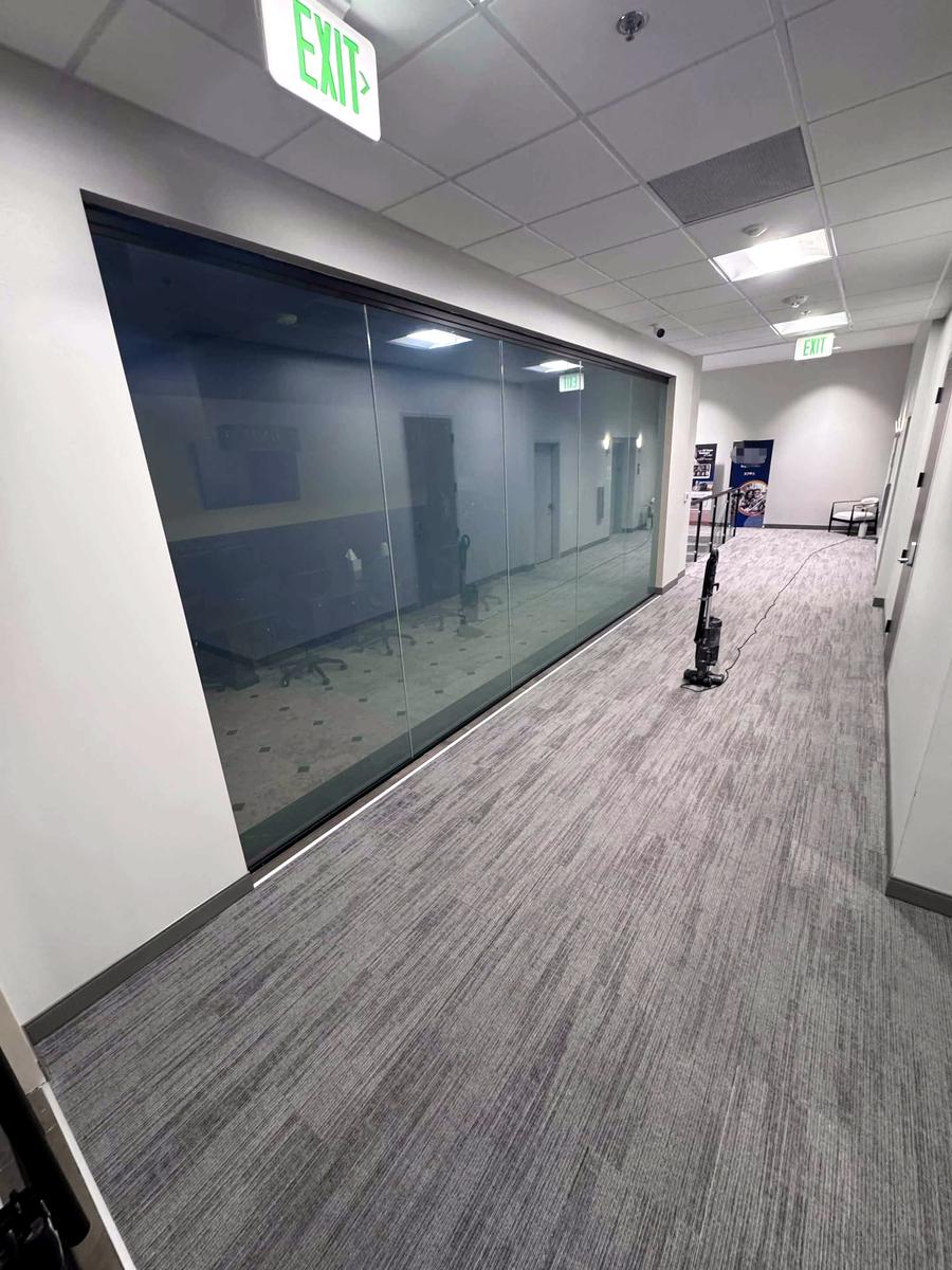 A long, freshly cleaned glass wall in an office hallway
