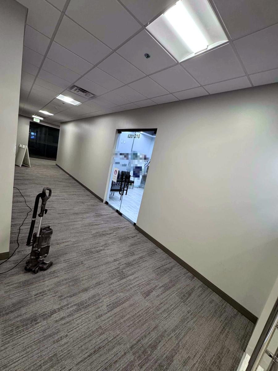 A vacuumed office corridor with a glass entry door