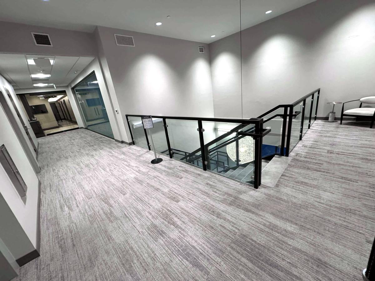 A clean second-floor landing with a glass railing