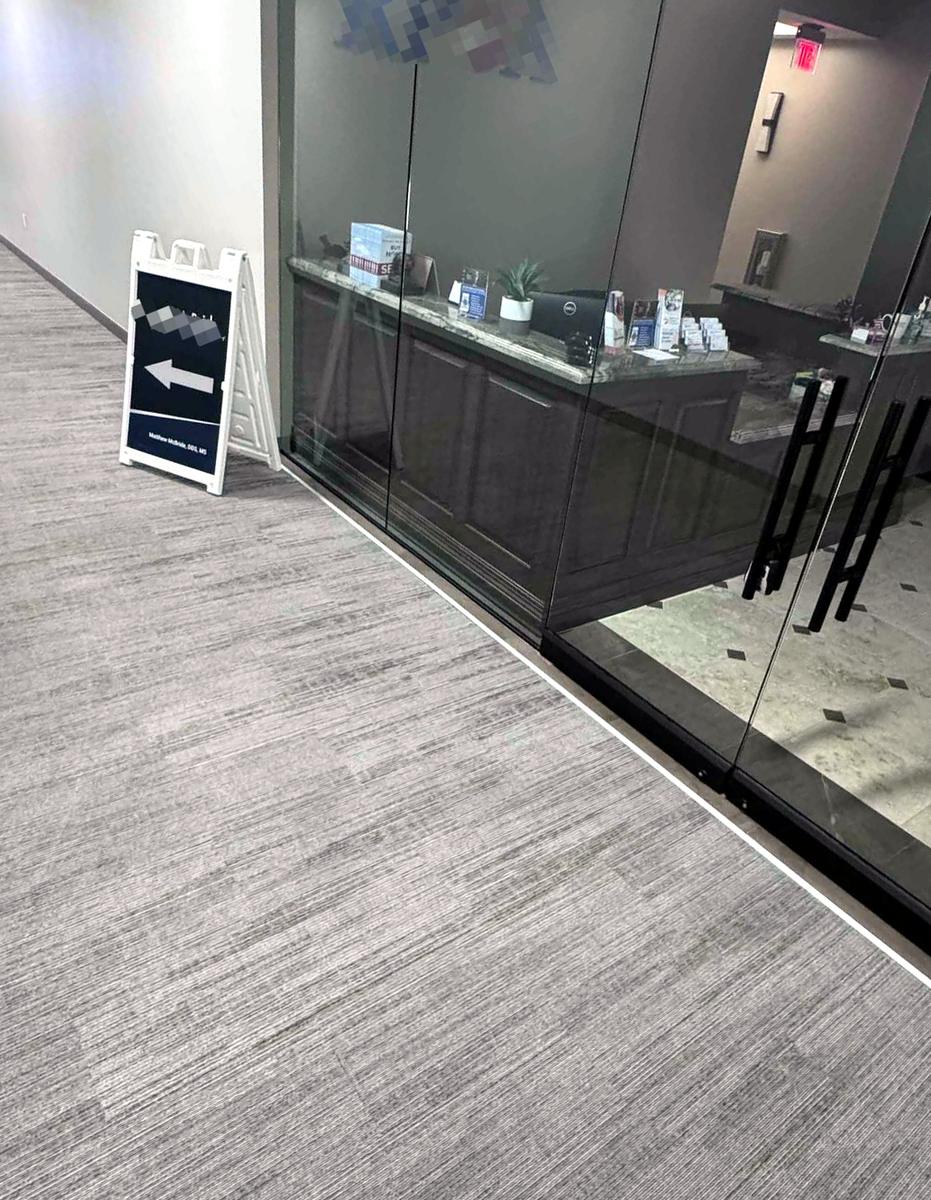 Clean carpet outside a glass-front reception area