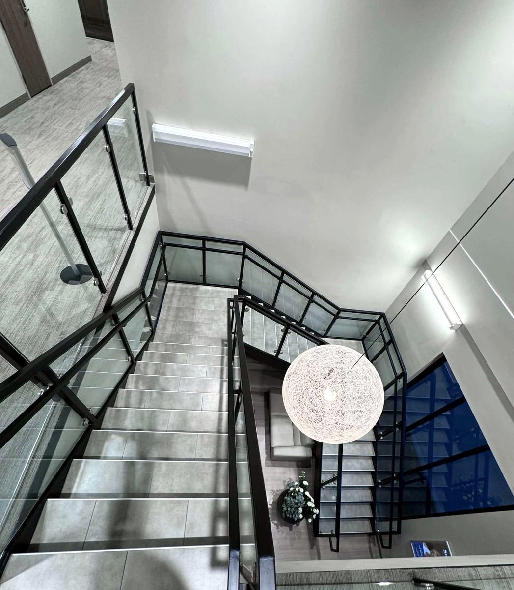 A clean glass and steel stairwell seen from above